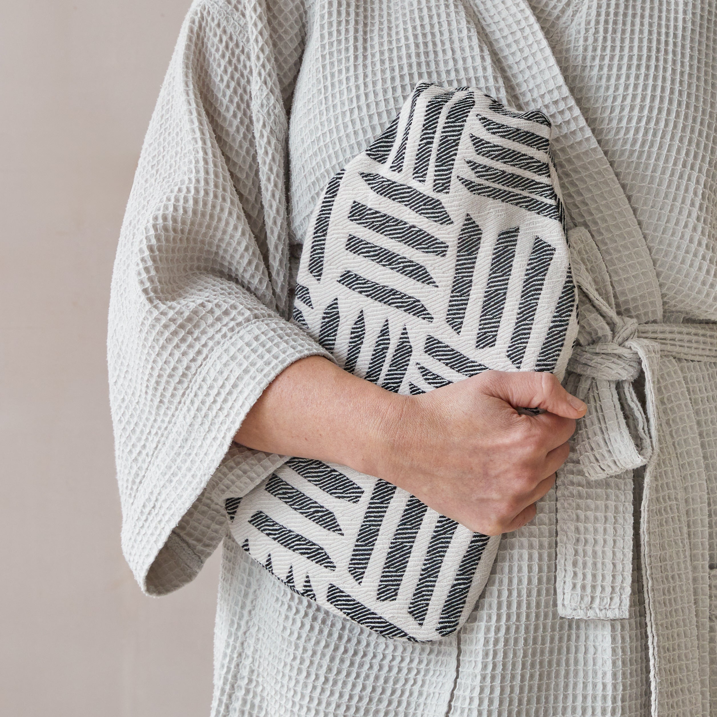 Beatrice Larkin weaved merino wool hot water bottle in cut light black and cream pattern.