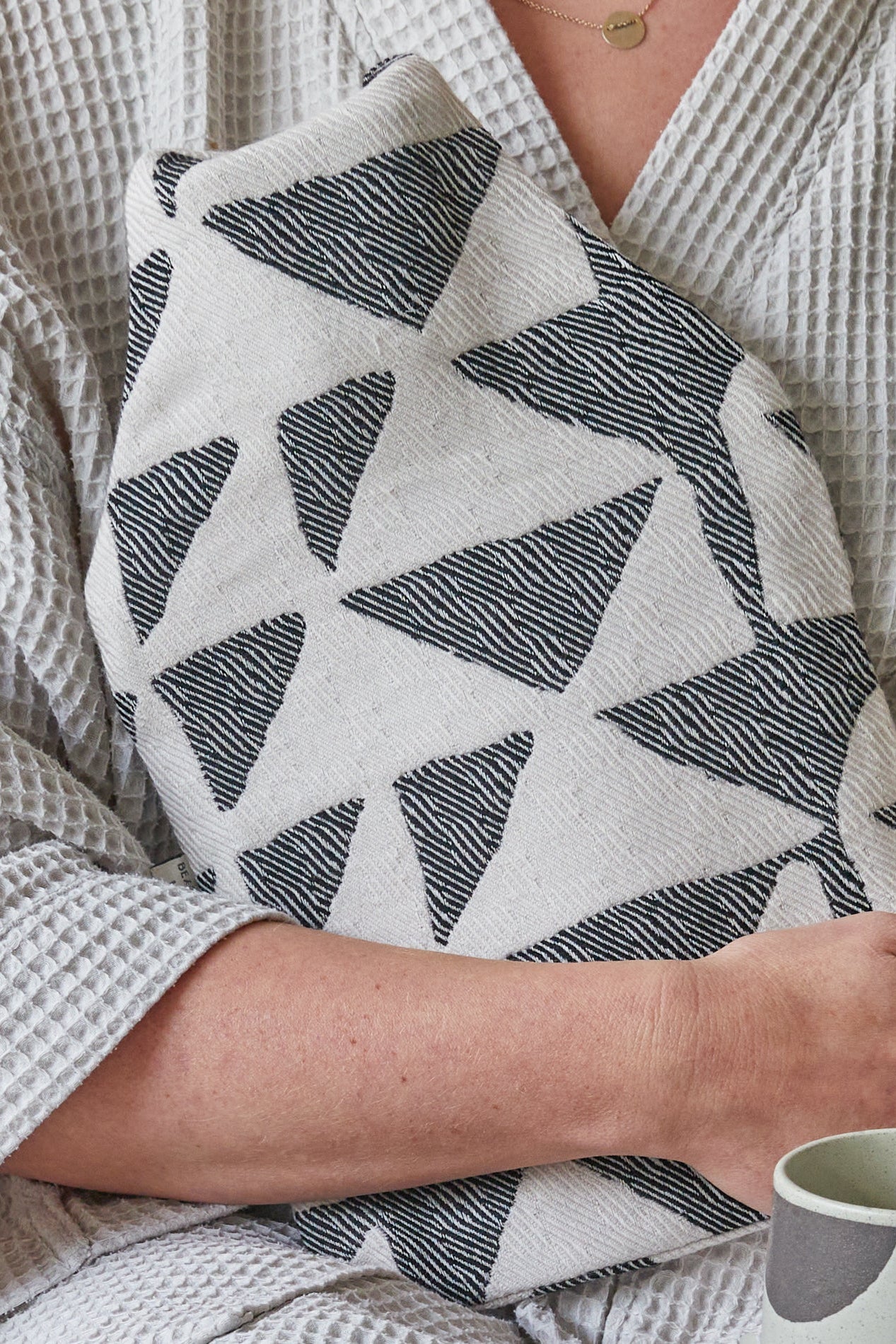 soft merino wool hot water bottle by British Maker Beatrice Larkin, black and white abstract pattern.