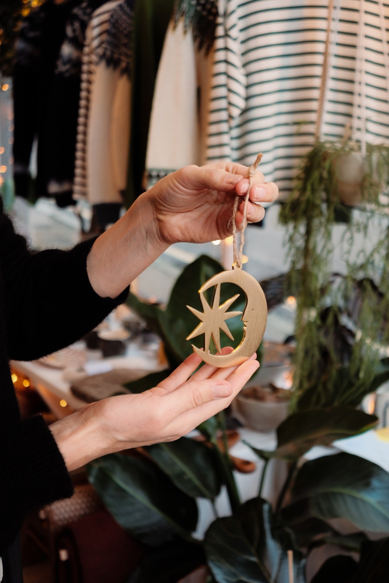 Person holding a decorative ornament with a star design in a festive setting.