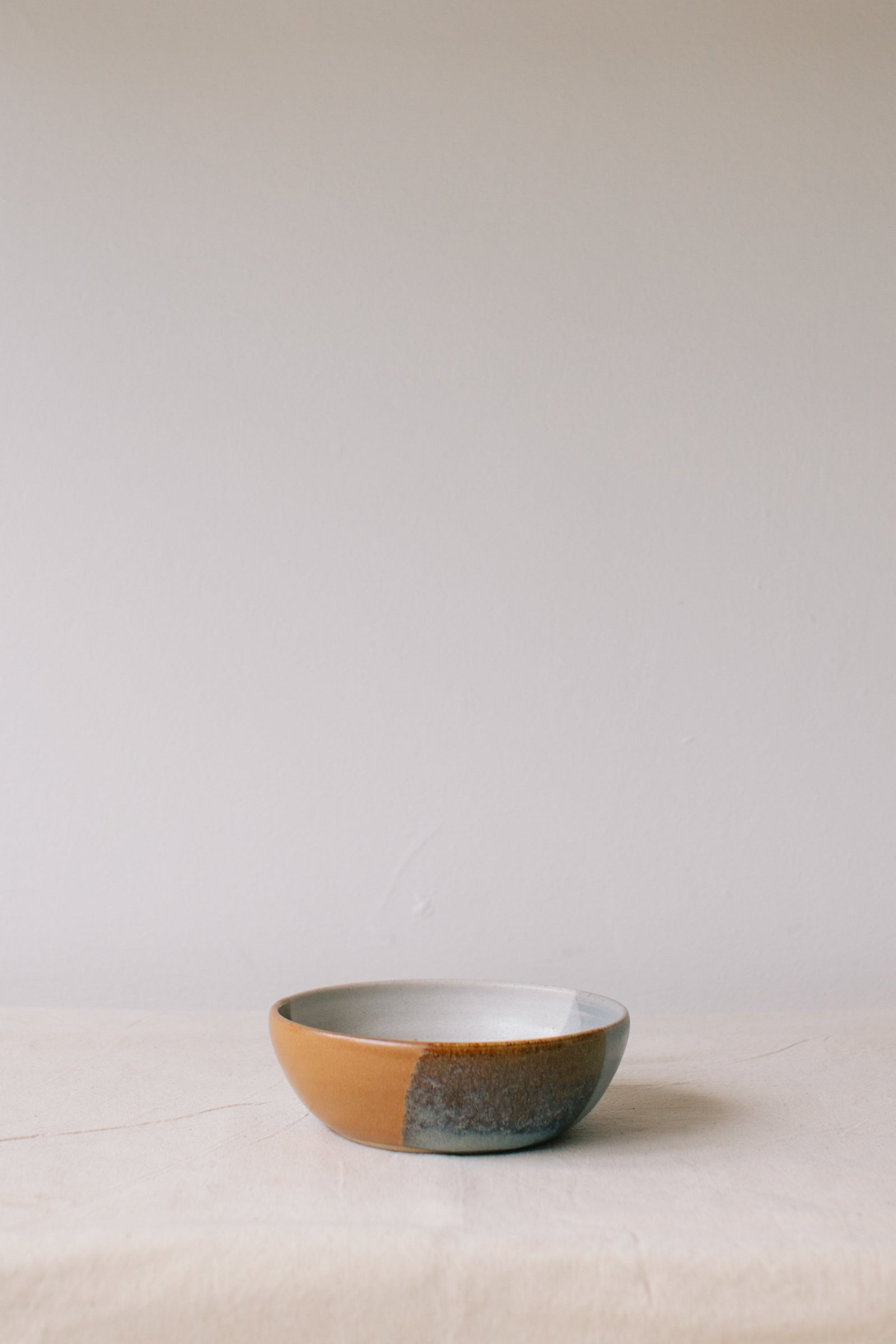 Handmade ceramic bowl by Liz Vidal. This bowl is the perfect size for breakfast, salads or soups. Liz uses different tones of rust and brown glaze to dip her bowls to create an abstract landscape design.