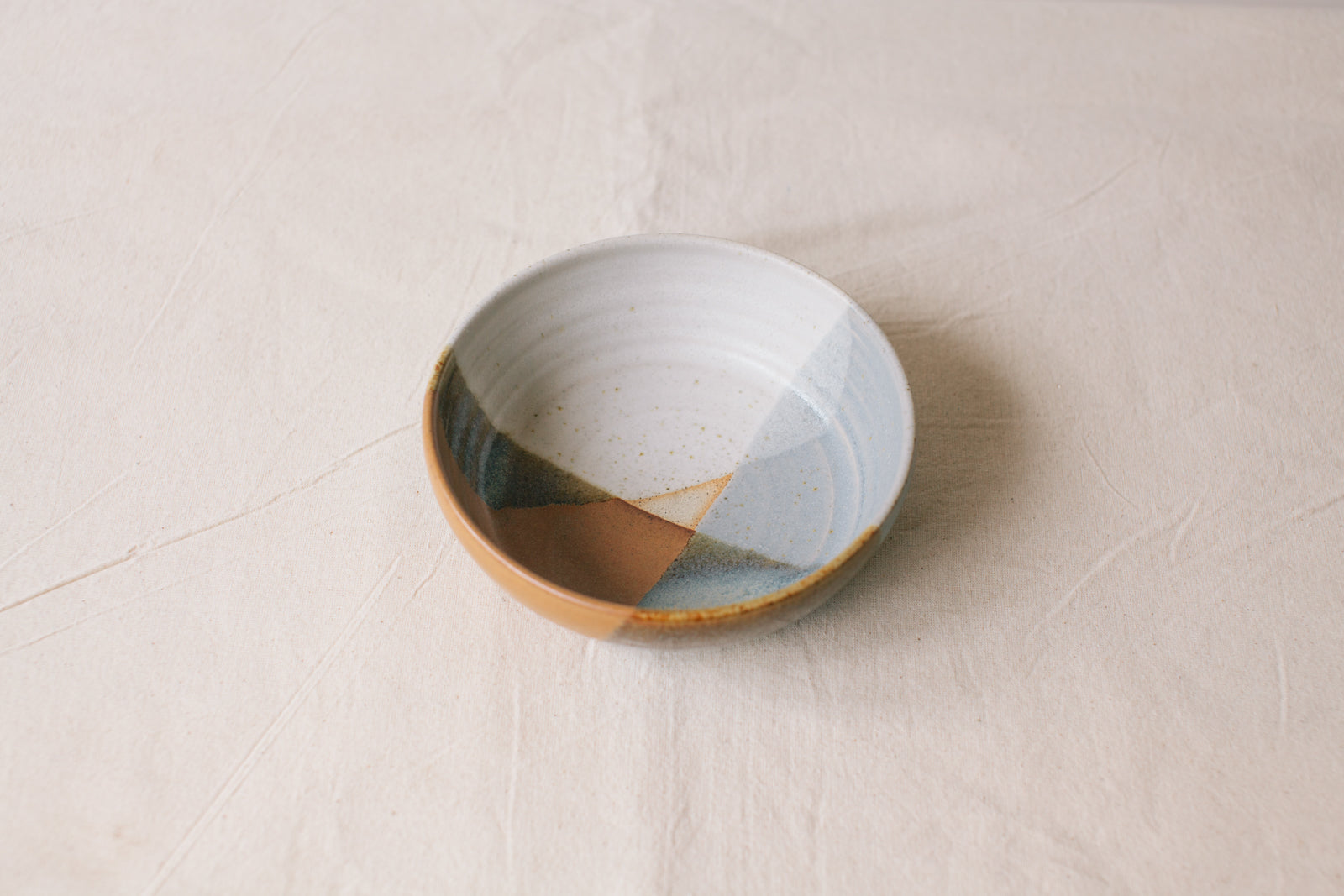 Handmade ceramic bowl by Liz Vidal. This bowl is the perfect size for breakfast, salads or soups. Liz uses different tones of rust and brown glaze to dip her bowls to create an abstract landscape design.