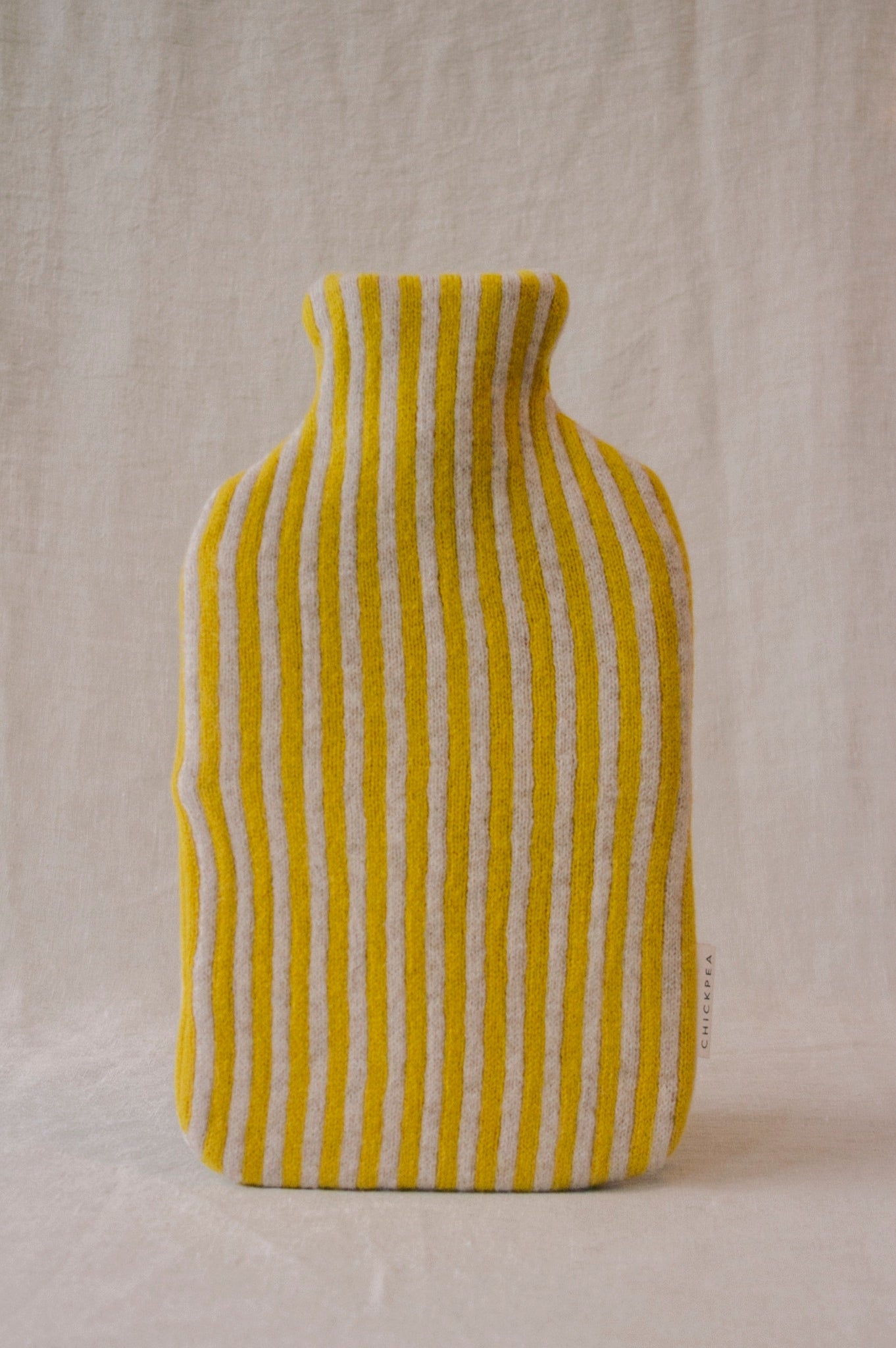 Yellow and white striped vase on a beige background