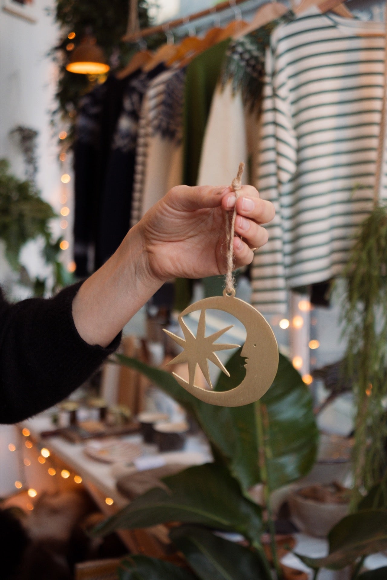 Hand holding a gold decorative item with a star design in a store setting