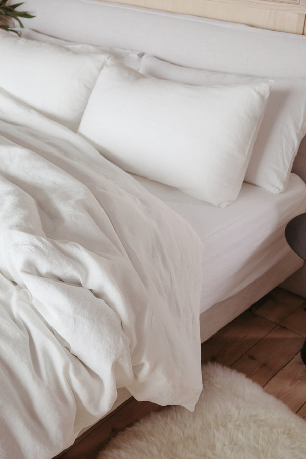 styled shot of bed with linen bedding in white for Ondine Ash Falmouth