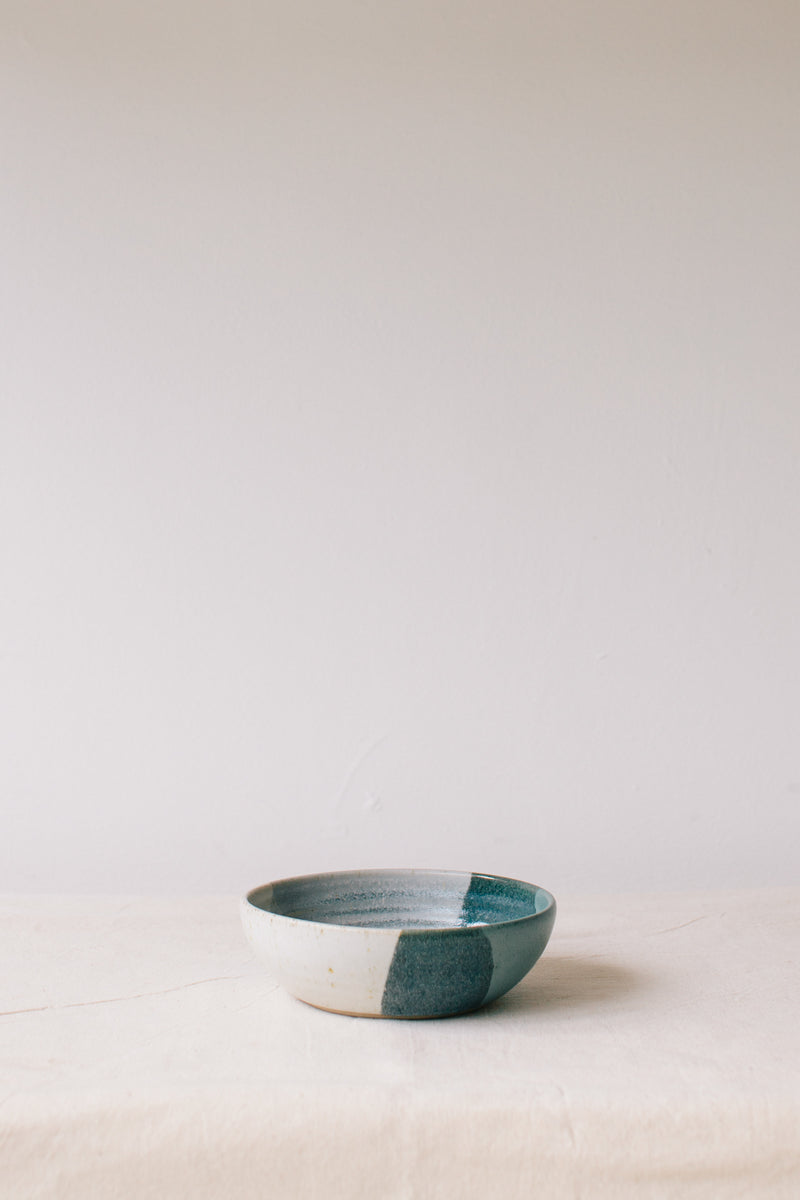 Handmade ceramic bowl by Liz Vidal. This bowl is the perfect size for breakfast, salads or soups. Liz uses different tones of blue glaze to dip her bowls to create an abstract landscape design.